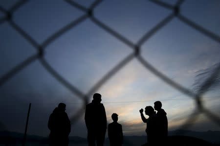 Migrants who are waiting to cross the Greek-Macedonian border, chat at a makeshift camp near the village of Idomeni, Greece March 8, 2016. REUTERS/Marko Djurica