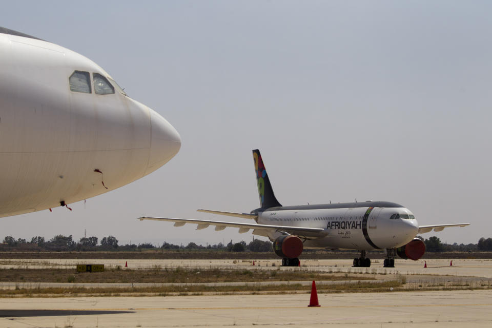 FILE - In this Aug. 20, 2011, file, photo taken on a government-organized tour, airplanes are parked in the tarmac of the international airport in Tripoli, Libya. The only functioning airport in Libya's capital suspended its operations after coming under attack Wednesday, Jan. 22, 2020, airport authorities said, despite a tenuous truce that world powers have pushed warring parties to respect. Authorities at Mitiga airport said six Grad missiles crashed into the tarmac. (AP Photo/Dario Lopez-Mills, File)