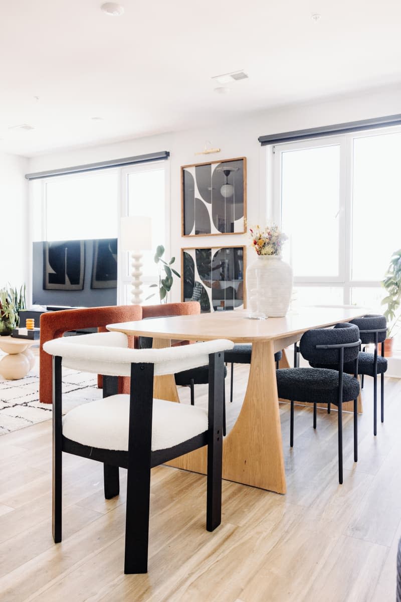 white dining room with black and white chairs and oval light wood table