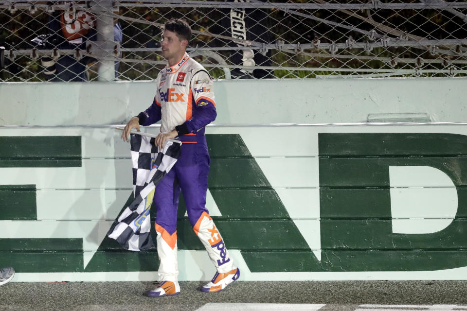 Denny Hamlin celebrates with the checkered flag after winning a NASCAR Cup Series auto race Sunday, June 14, 2020, in Homestead, Fla. (AP Photo/Wilfredo Lee)