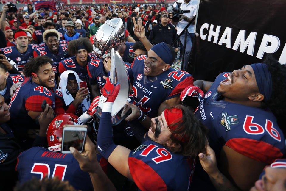 Fresno State players celebrate with the trophy after defeating Arizona State in the Las Vegas Bowl NCAA college football game, Saturday, Dec. 15, 2018, in Las Vegas. Fresno State won 31-20. (AP Photo/John Locher)