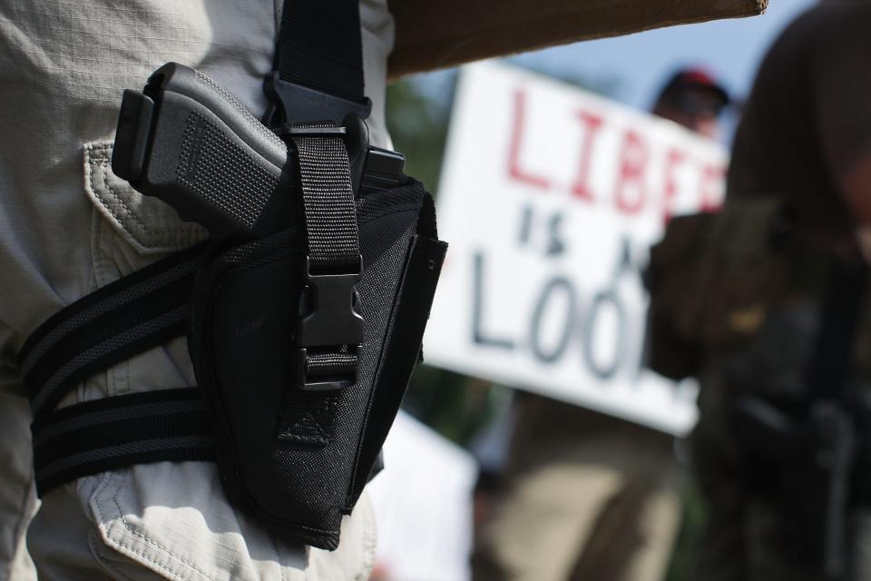 An armed gun rights activist counterprotests during a rally outside the headquarters of the National Rifle Association on July 14, 2017, in Fairfax, Va.