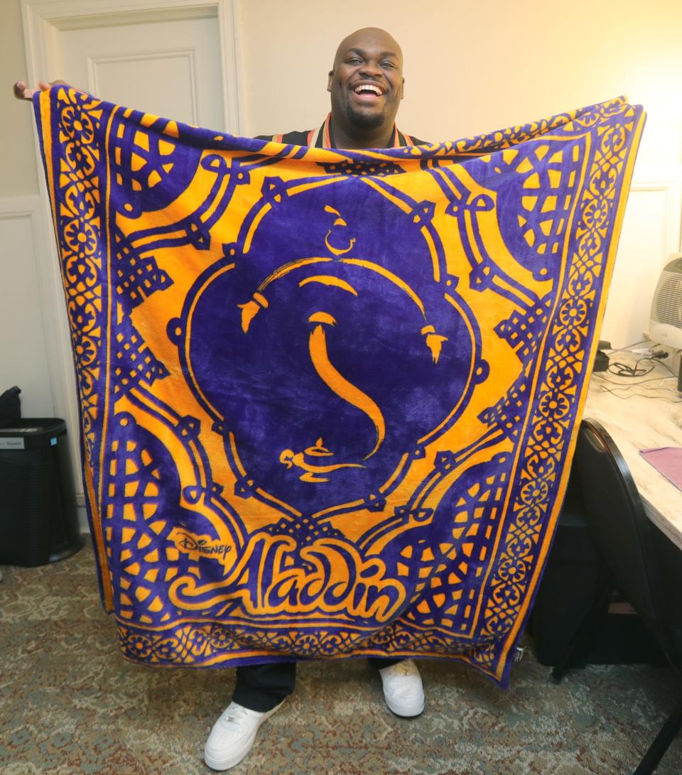 Akron native Marcus Martin, in his dressing room at Playhouse Square, shows the "Aladdin" blanket his mother gave him for his North American tour as Genie.