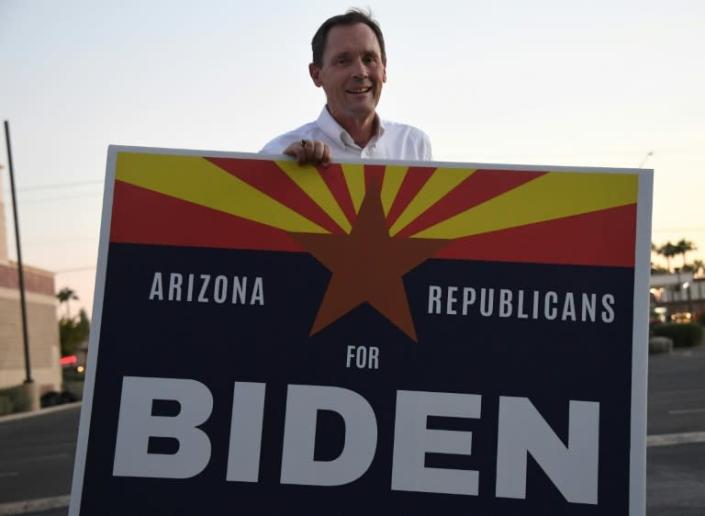 Dan Barker, a retired judge who so dislikes US President Donald Trump that he created the group "Arizona Republicans Who Believe In Treating Others With Respect", poses with a sign to encourage voters to choose Democratic presidential candidate Joe Biden