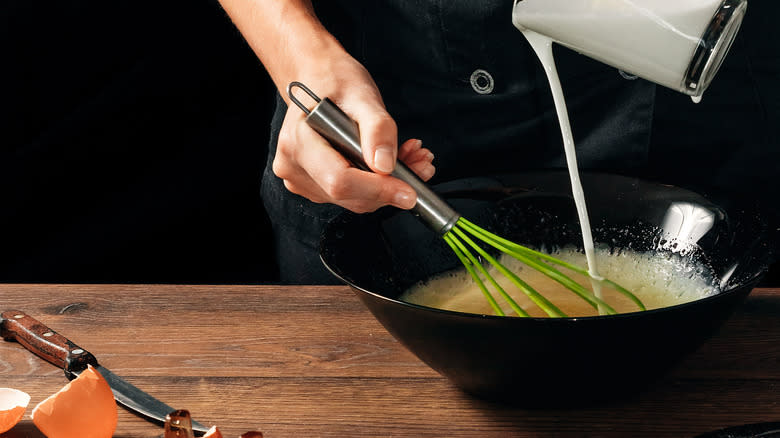 hand whisking cream into eggs