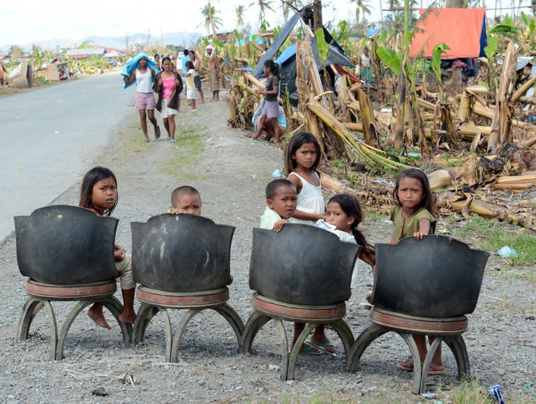 Children wait for relief goods in the southern town of New Bataan on December 12, 2012. Residents of New Bataan, which suffered over 500 dead, are still struggling to recover, building makeshift shelters out of scrap wood and rags