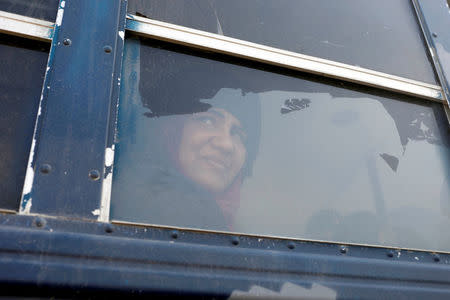 A displaced Iraqi woman, who just fled her home, looks on through a bus window on her way to a refugee camp, as Iraqi forces battle with Islamic State militants, in western Mosul, Iraq March 9, 2017. REUTERS/Zohra Bensemra