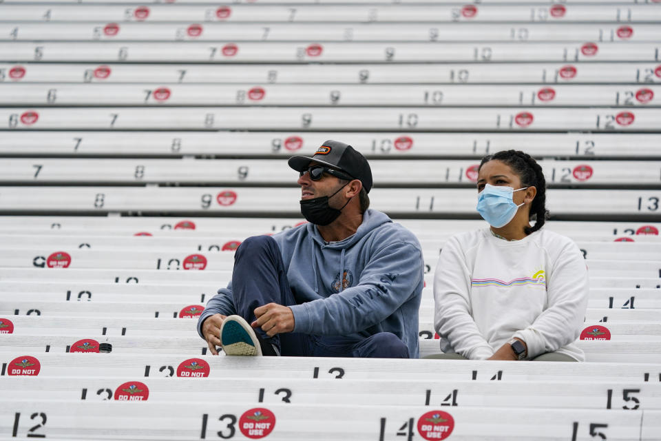 Fans sit in the stands as rain delayed the start of the final practice session for the Indianapolis 500 auto race at Indianapolis Motor Speedway in Indianapolis, Friday, May 28, 2021. Seats are marked "Do Not Use" to encourage social distancing. (AP Photo/Michael Conroy)