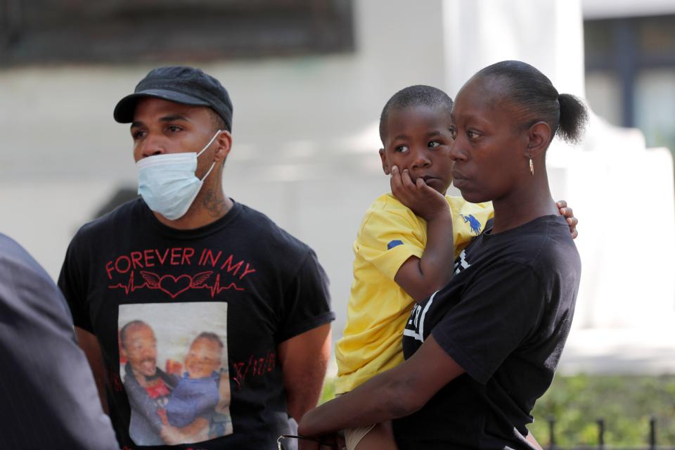 Maria Scott holds her son as she stands with her fiancé's brother Marque Jerido during a press conference about the killing of her fiancé, Maurice Mincey, during a traffic stop by Savannah Police.