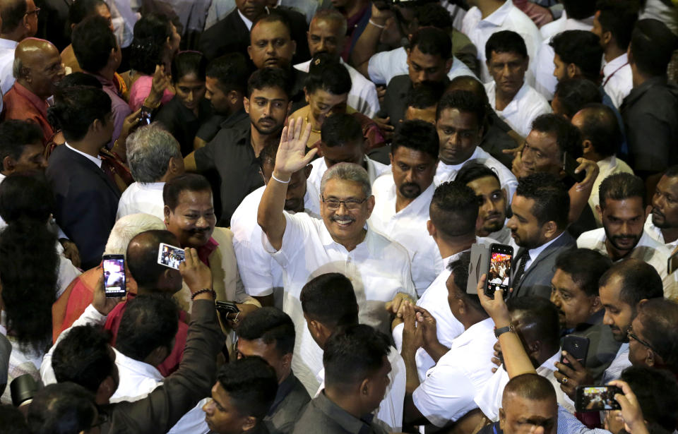 FILE - In this Aug. 11, 2019, file photo, former Sri Lankan Defense Secretary Gotabaya Rajapaksa waves to supporters during a party convention held to announce the presidential candidacy in Colombo, Sri Lanka. Gotabaya is a feared former defense official accused of human rights abuses and crushing critics, but to many Sri Lankans, he is the leader most needed after last April’s Easter bomb attacks that killed more than 250 people. (AP Photo/Eranga Jayawardena, File)