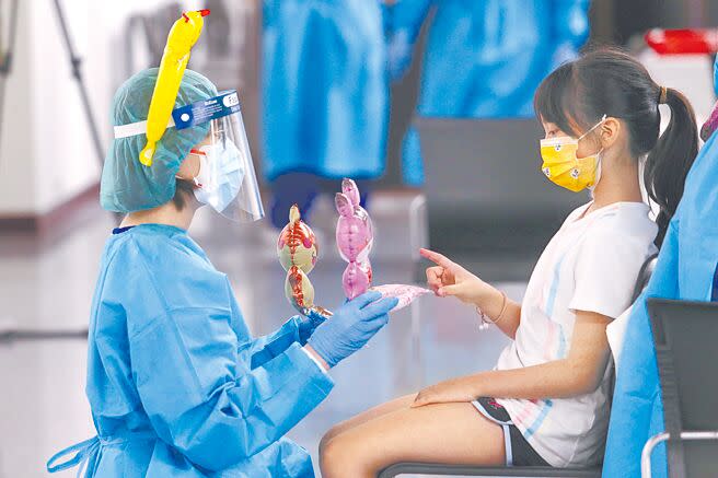 台北榮總醫護人員戴著可愛的充氣頭飾，送上氣球玩偶，安撫孩童們對打針的恐懼。（黃世麒攝）