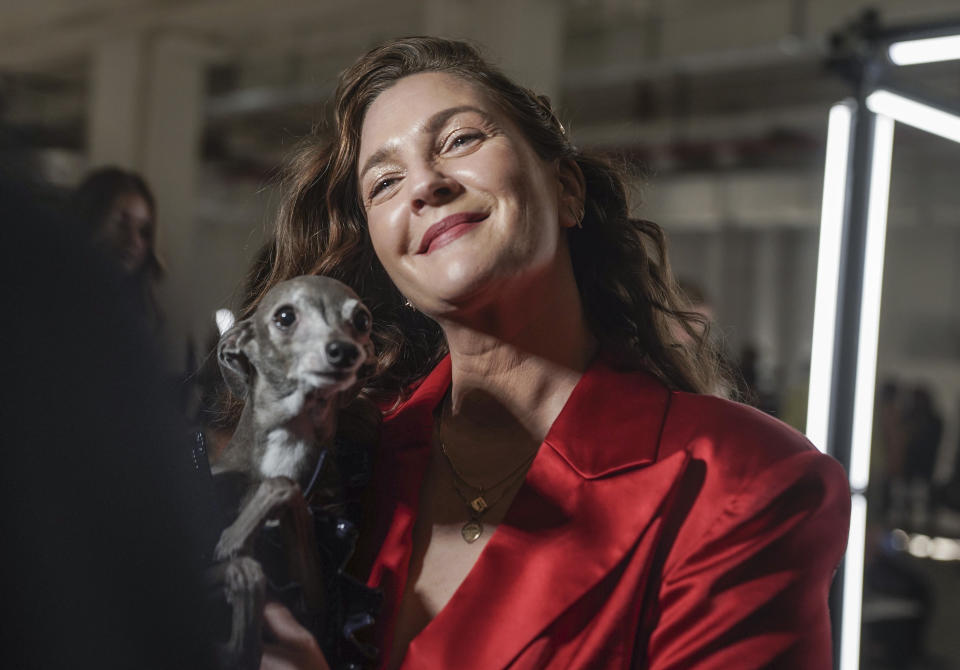 Drew Barrymore holds her dog during an interview before viewing Christian Siriano's fall/winter 2022 fashion collection, Saturday Feb. 12, 2022, in New York. (AP Photo/Bebeto Matthews)