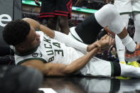 Milwaukee Bucks' Giannis Antetokounmpo lies by the basket after injuring his right wrist during the first half of the team's NBA basketball game against the Chicago Bulls on Thursday, Feb. 16, 2023, in Chicago. (AP Photo/Charles Rex Arbogast)
