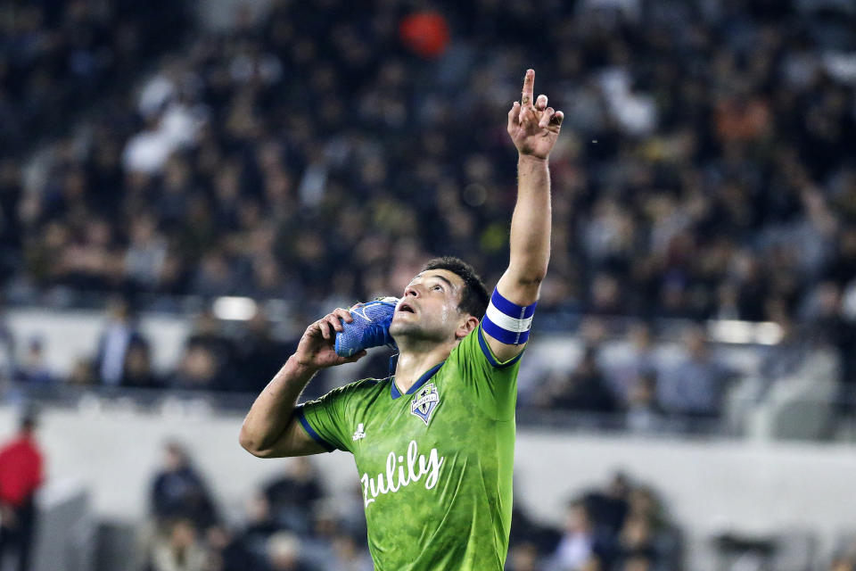 Seattle Sounders midfielder Nicolas Lodeiro celebrates his goal while holding his shoe during the first half of the team's MLS soccer Western Conference final against Los Angeles FC, Tuesday, Oct. 29, 2019, in Los Angeles. (AP Photo/Ringo H.W. Chiu)