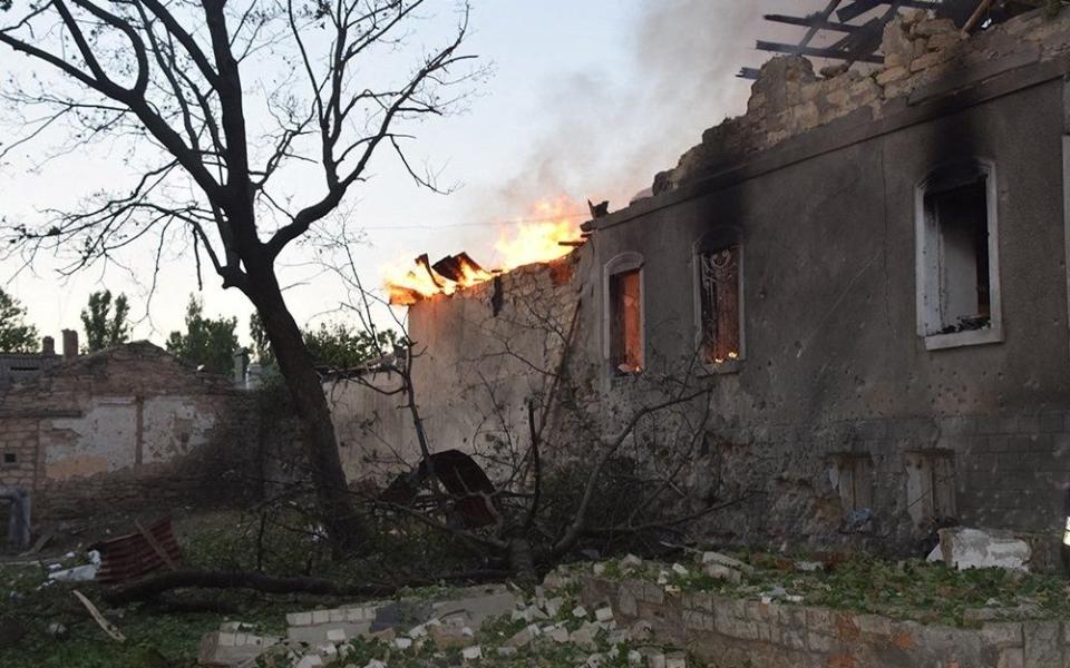 A firefighter works to douse a fire in a building, as Russia's attack on Ukraine continues, in Mykolaiv - REUTERS