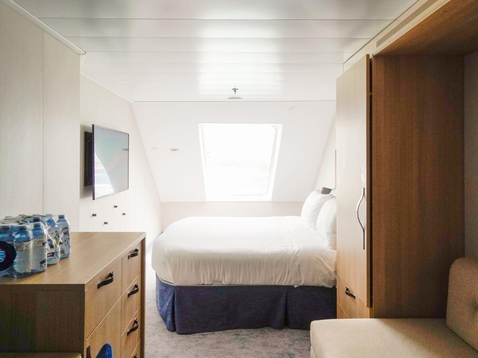A cruise ship cabin with a window in the back