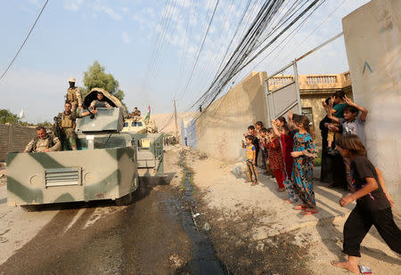 Children welcome Kurdish Peshmerga fighters after peshmerga recaptured from Islamic state militant, the Fadiliya village in Nawaran, north of Mosul, Iraq, October 27, 2016. REUTERS/Air Jalal