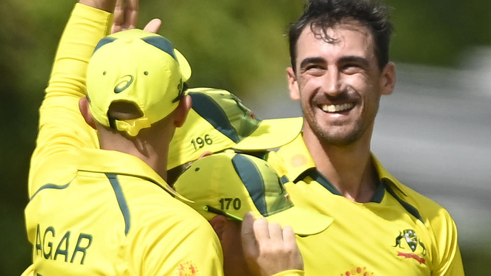 Mitchell Starc celebrates one of his three wickets against Zimbabwe with Australian teammates.