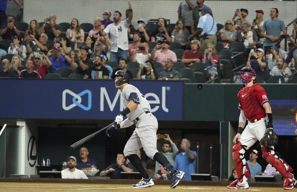 New York Yankees' Aaron Judge, left, watches his solo home, his 62nd of the season, with Texas Rangers catcher Sam Huff during the first inning in the second baseball game of a doubleheader in Arlington, Texas, Tuesday, Oct. 4, 2022. With the home run, Judge set the AL record for home runs in a season, passing Roger Maris. (AP Photo/LM Otero)