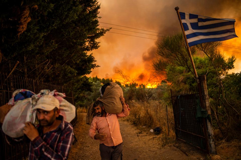 People try to move parts of their belongings to safety as a forest fire rages in a wooded area north of Athens. The fire north of Athens flared up again on August 05, 2021.