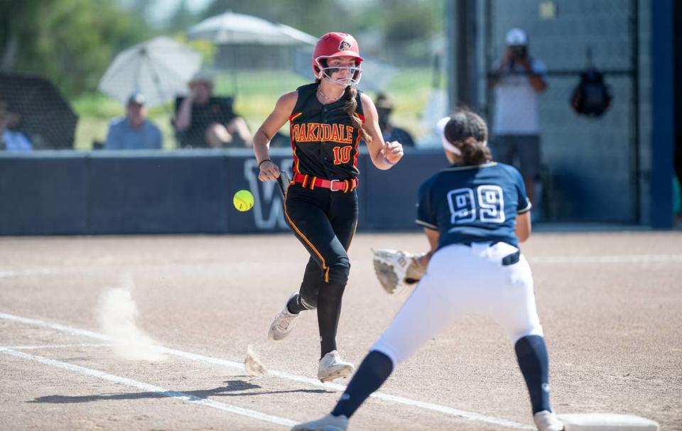 Oakdale’s Morgan Merzon runs safely to first base on a passed ball during the Valley Oak League game at Central Catholic High School in Modesto, Calif., Tuesday, April 25, 2023.