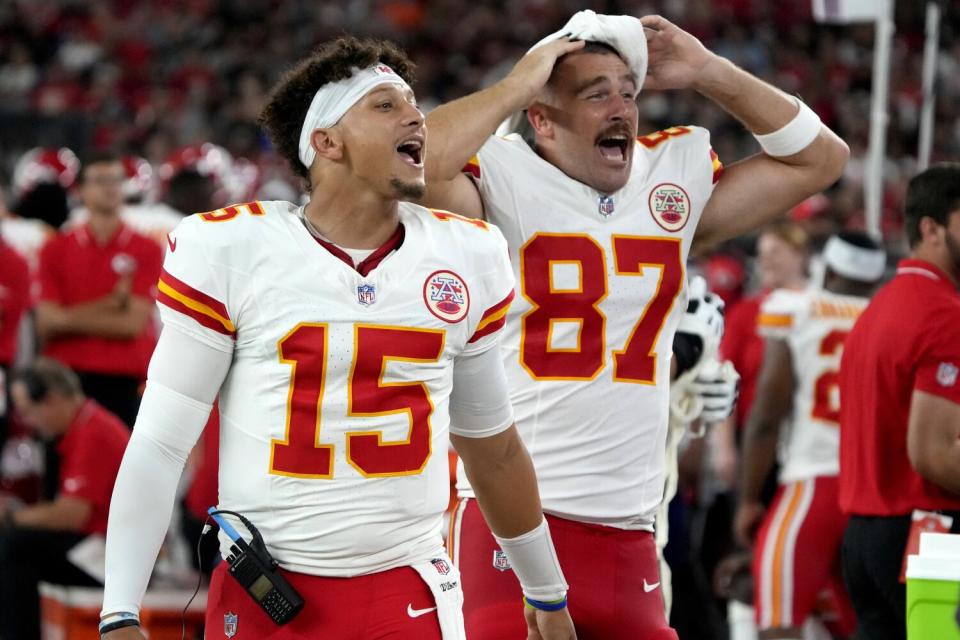 Kansas City Chiefs quarterback Patrick Mahomes (15) and tight end Travis Kelce (87) cheer from the sidelines.