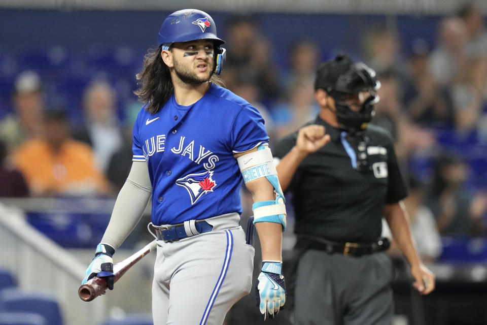 Toronto Blue Jays' Bo Bichette, left, looks back after being called out on strikes during the first inning of a baseball game against the Miami Marlins, Monday, June 19, 2023, in Miami. (AP Photo/Lynne Sladky)