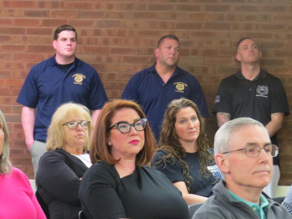Rockaway Township police officers stand as their PBA representative discusses stalled contract negotiations during Tuesday's council meeting