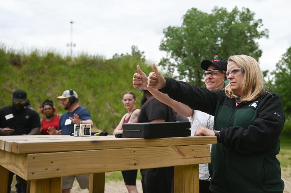 Jamie Gebhart, right, of Lansing works with 'Ladies Night at the Range' administrator Nettie Chronister, on hand placement and pistol sight windows during a range instruction session at the Capital Area Sportsmens League pistol range in Delta Township.