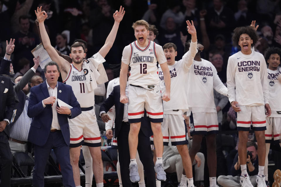 UConn guard Cam Spencer (12) and teammates celebrate during the final minutes of the team's NCAA college basketball game against Marquette for the championship of the Big East men's tournament Saturday, March 16, 2024, in New York. (AP Photo/Mary Altaffer)