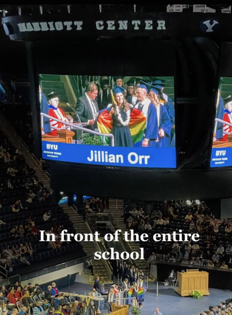 During her graduation ceremony, Jillian can be seen on a huge Jumbotron screen flashing her Pride flag