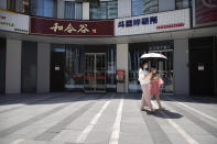 People wear face masks to protect against the coronavirus as they walk at a retail and office complex in Beijing, Friday, June 5, 2020. China on Friday reported five new confirmed coronavirus cases, all of them brought by Chinese citizens from outside the country. (AP Photo/Mark Schiefelbein)