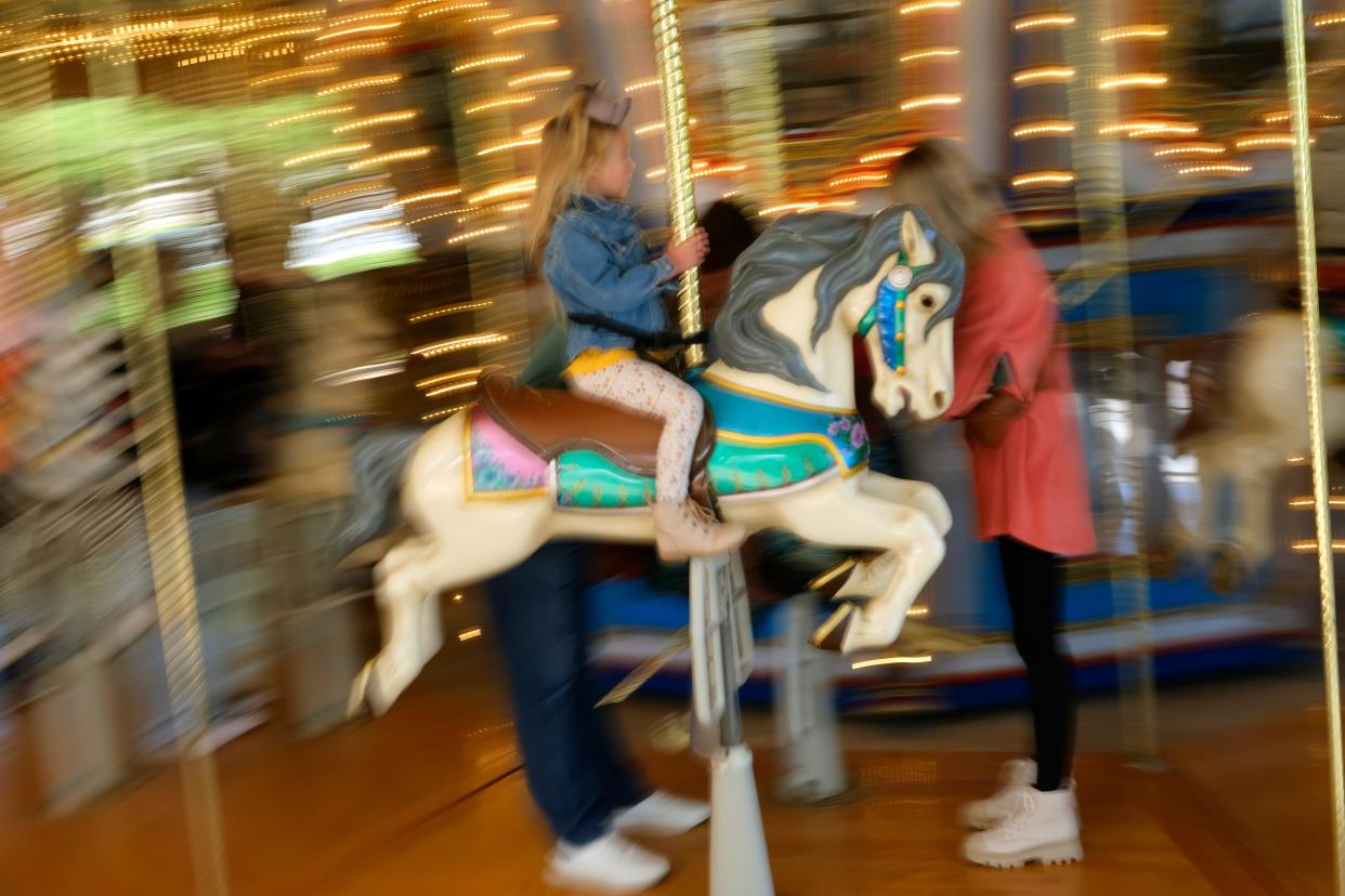 A child rides on Mo's Carousel at Pumpkinville: Witches and Wizards, in the Children's Garden area of the Myriad Botanical Gardens Monday, October 17, 2022.