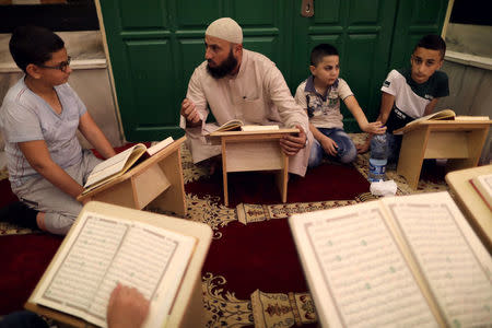 A Palestinian Sheikh teaches children to read the Koran inside al-Aqsa Mosque, on the compound known to Muslims as al-Haram al-Sharif and to Jews as Temple Mount, in Jerusalem's Old City, May 17, 2017. REUTERS/Ammar Awad