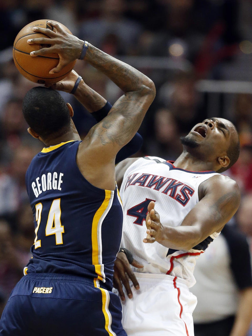 Indiana Pacers forward Paul George (24) collides with Atlanta Hawks forward Paul Millsap (4) in the second half of Game 3 of an NBA basketball first-round playoff series on Thursday, April 24, 2014, in Atlanta. The Hawks won 98-85. (AP Photo/John Bazemore)