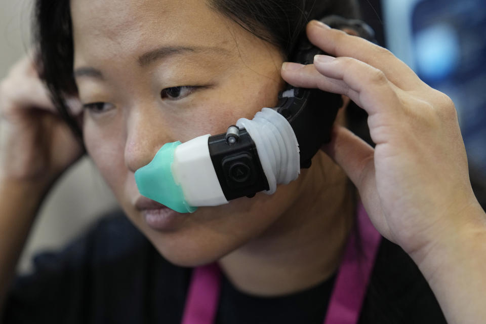 An exhibitor displays the OVR Technology ION 3 stand-alone wearable at the OVR Technology booth during the CES tech show Thursday, Jan. 5, 2023, in Las Vegas. The ION 3 is a wearable device that delivers scents using cartridges, and the delivery system is synchronized with the content users are viewing in VR, AR, and mobile or desktop computing devices. (AP Photo/John Locher)