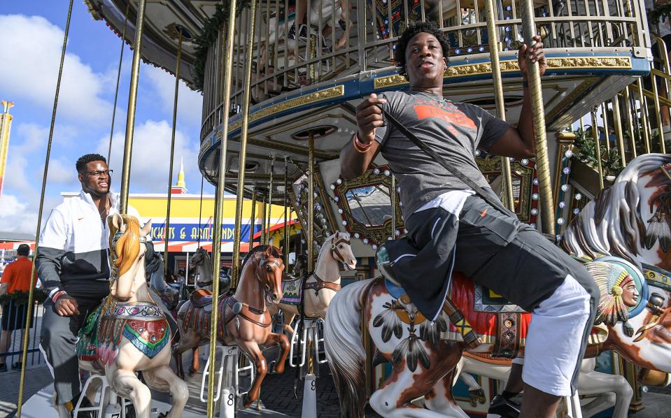 Clemson defensive end K.J. Henry, right, and defensive end Myles Murphy, left, ride a merry-go-round during the Cheez-It Bowl Day for Kids at Fun Spot America theme park in Orlando, Florida Monday, December 27, 2021. Henry said it was one of his favorite rides of the day. 