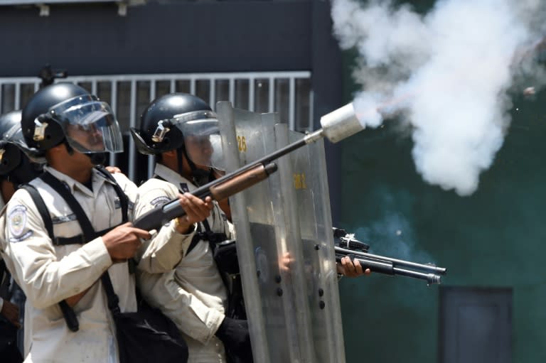 Riot police throw tear gas during clashes with demonstrators against Nicolas Maduro's government in Caracas on April 8, 2017