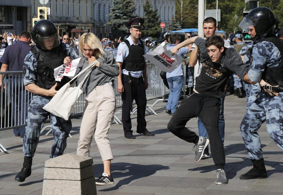 Police officers detain people during an unsanctioned rally in the center of Moscow, Russia, Saturday, July 27, 2019. Russian police on Saturday began arresting people outside the Moscow mayor's office ahead of an election protest demanding that opposition candidates be allowed to run for the Moscow city council. (AP Photo/Alexander Zemlianichenko)