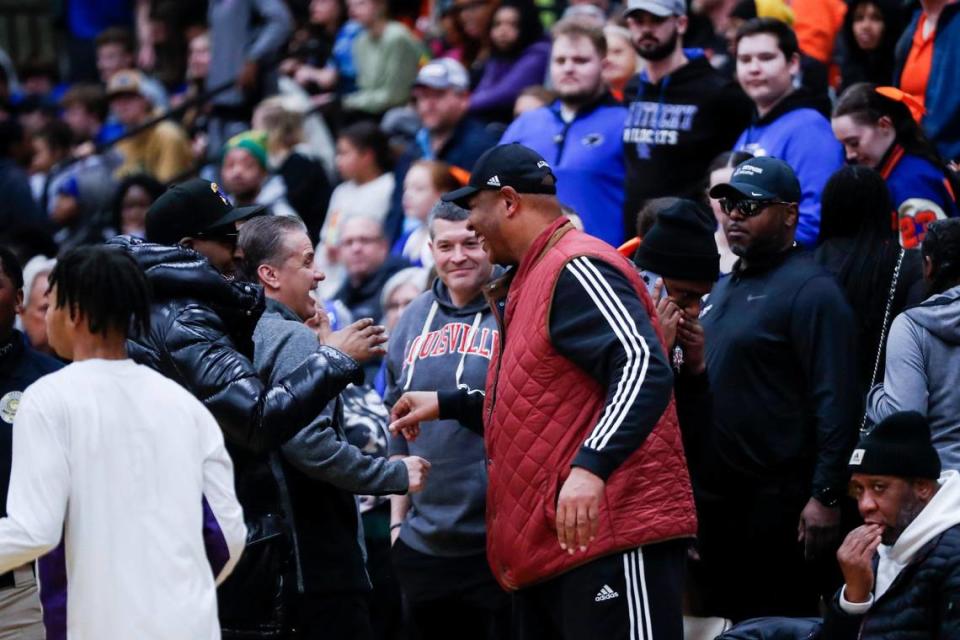 Kentucky head coach John Calipari shakes hands with Louisville head coach Kenny Payne before watching Camden (N.J.) High school face Combine Academy (N.C.).