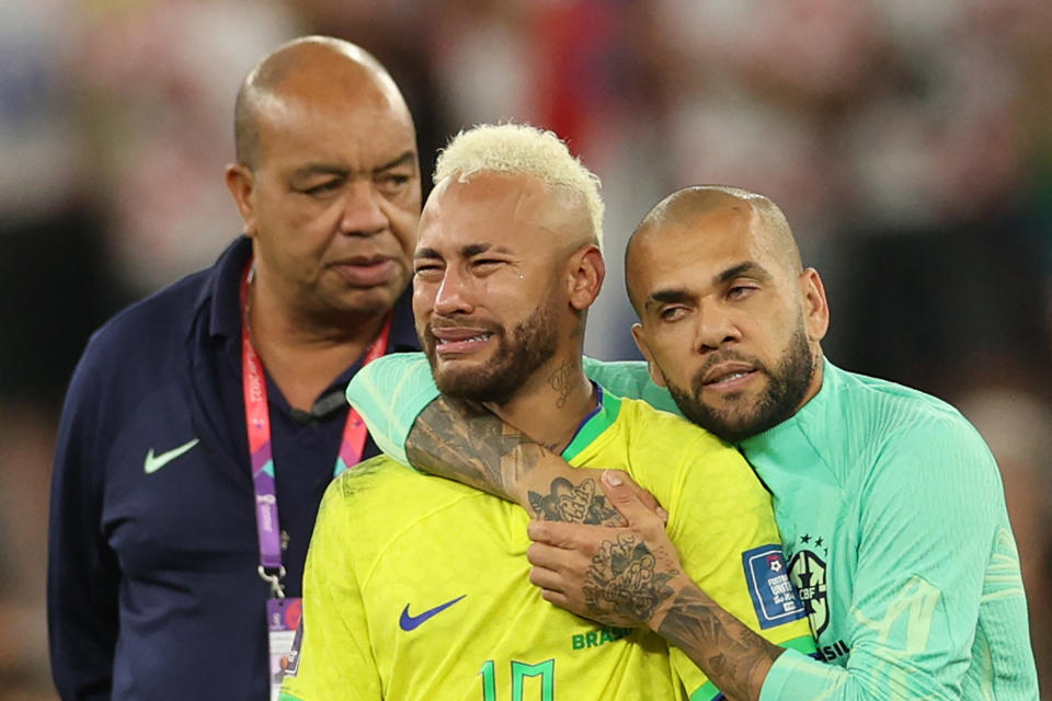 Brazil's forward #10 Neymar (C) is consoled by Brazil's defender #13 Dani Alves after their team lost the Qatar 2022 World Cup quarter-final football match between Croatia and Brazil at Education City Stadium in Al-Rayyan, west of Doha, on December 9, 2022. (Photo by Adrian DENNIS / AFP) (Photo by ADRIAN DENNIS/AFP via Getty Images)