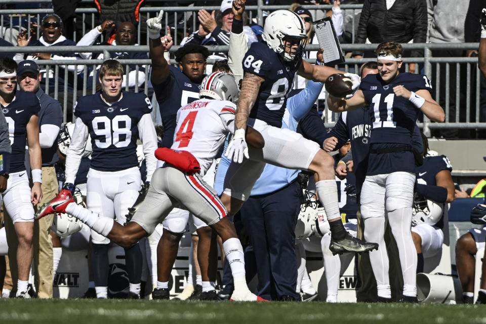 Penn State tight end Theo Johnson (84) gains yardage as Ohio State cornerback JK Johnson (4) chases him during the first half of an NCAA college football game, Saturday, Oct. 29, 2022, in State College, Pa. (AP Photo/Barry Reeger)