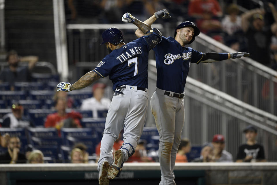 Milwaukee Brewers' Eric Thames (7) celebrates his two-run home run with Ryan Braun, right, during the 14th inning of a baseball game against the Washington Nationals, early Sunday, Aug. 18, 2019, in Washington. The Brewers won 15-14 in 14 innings. (AP Photo/Nick Wass)