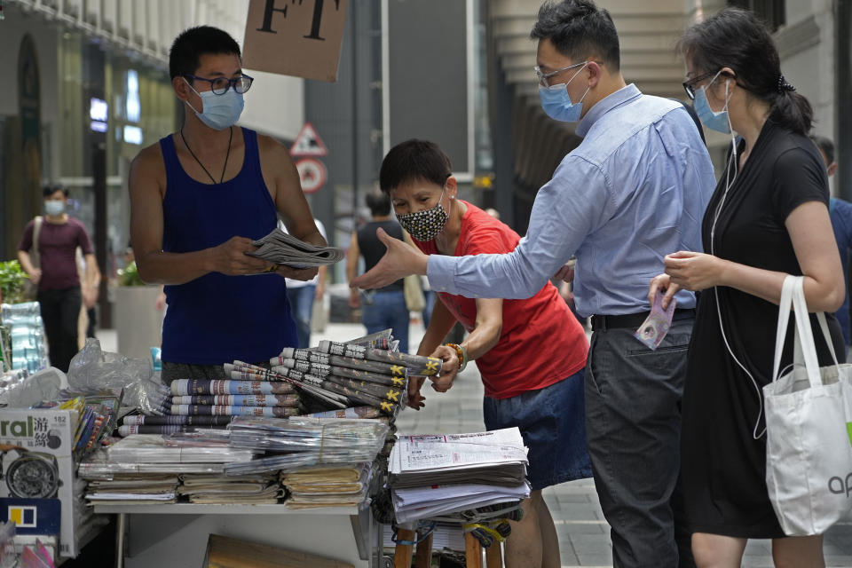 People queue up to buy Apple Daily at a downtown street in Hong Kong Friday, June 18, 2021. The pro-democracy paper increased its print run to 500,000 copies on Friday, a day after police arrested five top editors and executives and froze $2.3 million in assets linked to the media company. (AP Photo/Vincent Yu)