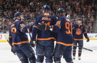 Edmonton Oilers' Zach Hyman (18), Mattias Ekholm (14) and Evander Kane (91) celebrate after a goal against the Buffalo Sabres during second-period NHL hockey game action in Edmonton, Alberta, Thursday March 21, 2024. (Jason Franson/The Canadian Press via AP)