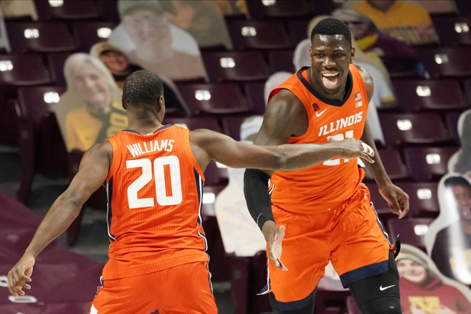 Illinois' Kofi Cockburn, right, celebrates one of his shots with Illinois' Da'Monte Williams (20) in the first half of an NCAA college basketball game, Saturday, Feb. 20, 2021, in Minneapolis. (AP Photo/Jim Mone)