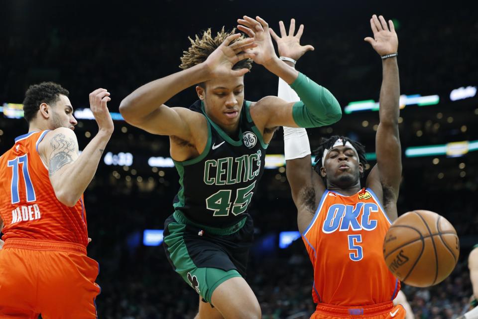 Boston Celtics' Romeo Langford (45) loses control of the ball against Oklahoma City Thunder's Abdel Nader (11) and Luguentz Dort (5) during the first half of an NBA basketball game, Sunday, March, 8, 2020, in Boston. (AP Photo/Michael Dwyer)