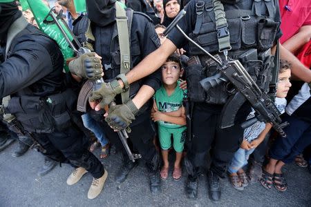 Palestinian boys stand next to Hamas militants as they take part in a military show against Israel's newly-installed security measures at the entrance to the al-Aqsa mosque compound, in Khan Younis, in the southern Gaza Strip July 20, 2017. REUTERS/Ibraheem Abu Mustafa