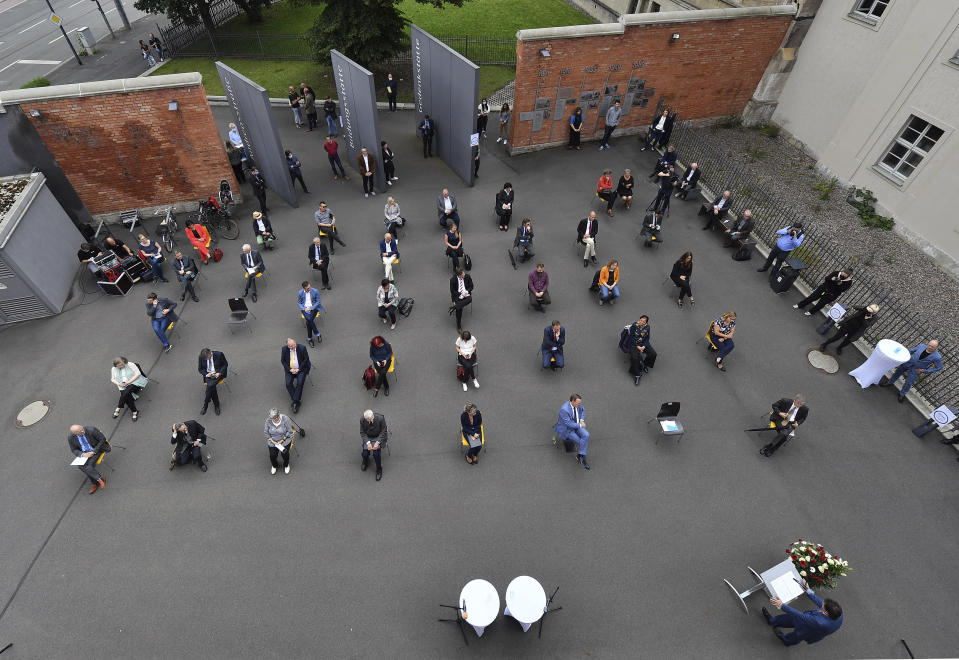 People sit in distance to prevent against the coronavirus during a commemorative event on June 17, 1953 take place at the Andreasstrasse Memorial in Erfurt, Germany, Tuesday, June 16, 2020. 67 years ago in former East Germany was a popular uprising which was bloodily suppressed. (Martin Schutt/dpa via AP)