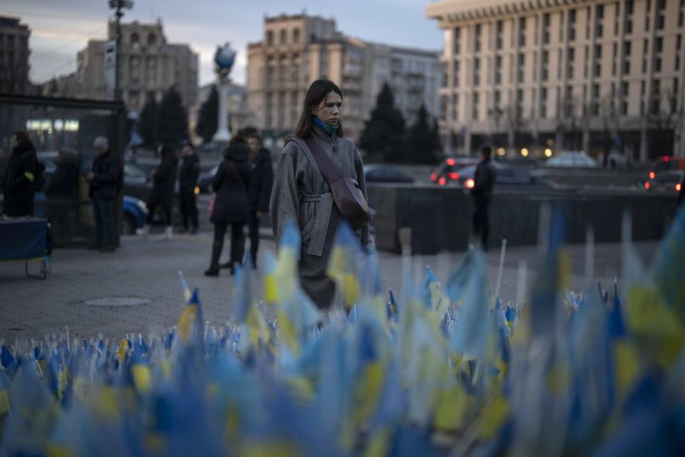 A woman looks at Ukrainian flags placed in memory of those killed during the war near Maidan Square in central Kyiv in January 2023. (AP Photo/Daniel Cole)